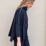 Woman wearing a navy blue outfit against a plain background