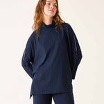 Woman wearing a navy blue outfit against a plain background