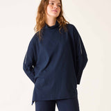 Woman wearing a navy blue outfit against a plain background