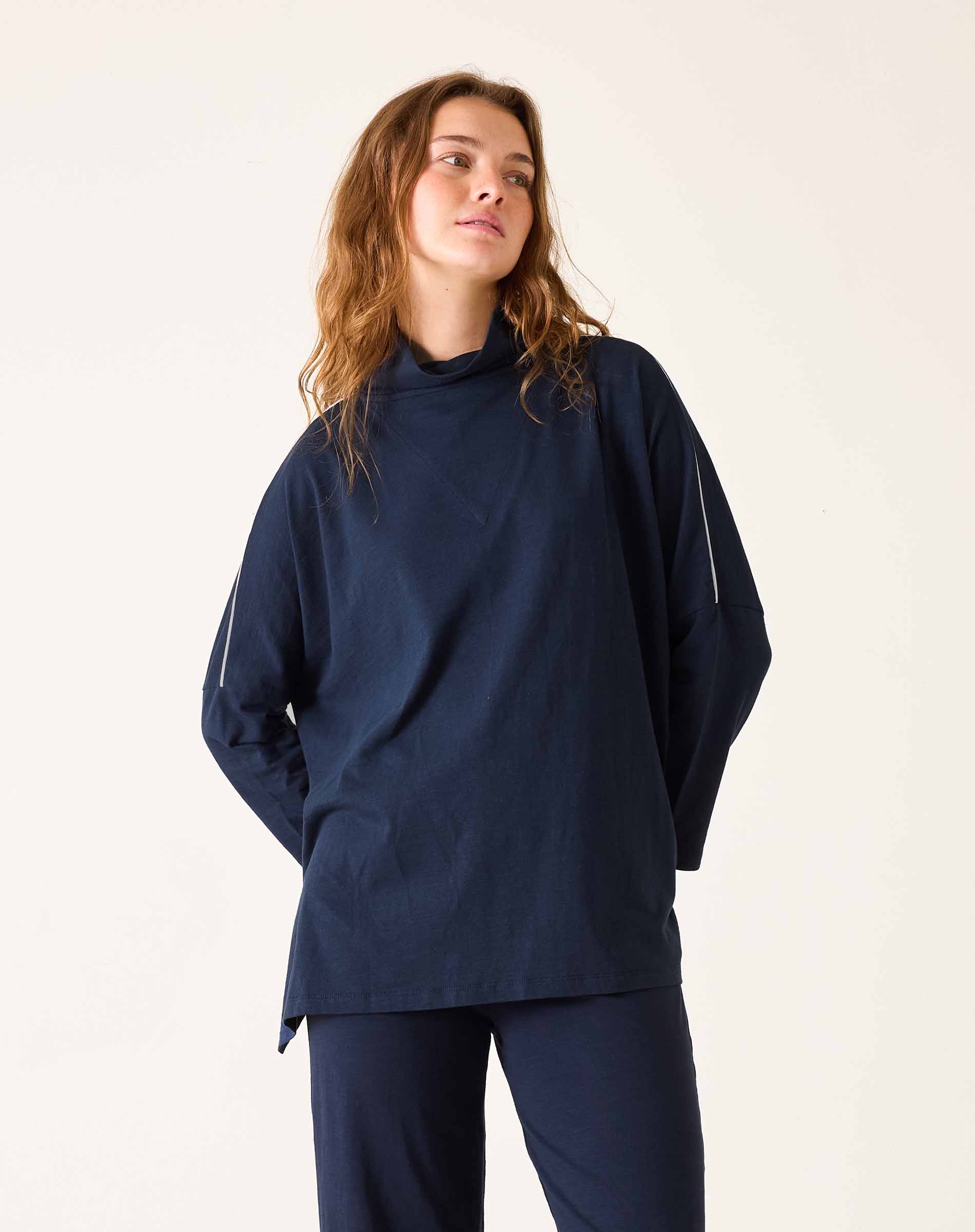 Woman wearing a navy blue outfit against a plain background