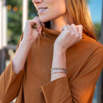 Woman wearing a brown shirt with a blurred outdoor background