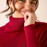 Wine red ribbed knit turtleneck sweater with long sleeves.