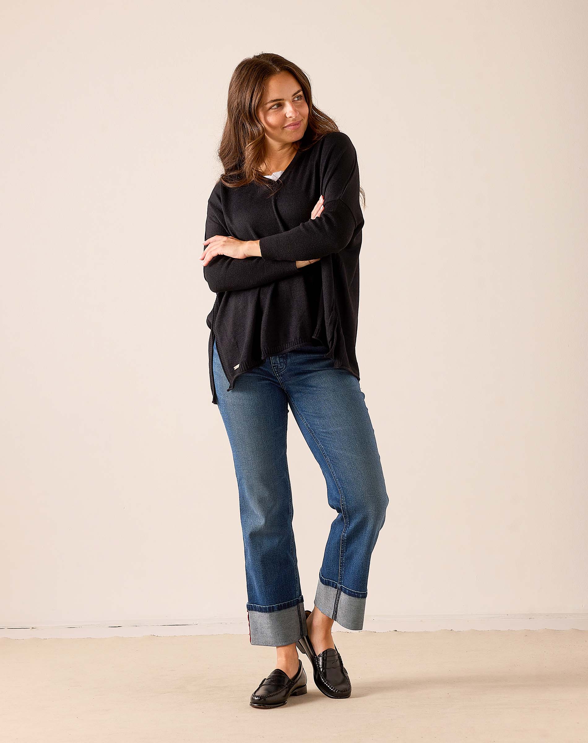 Women's travel-friendly black v-neck knit sweater with a relaxed fit and draped silhouette.