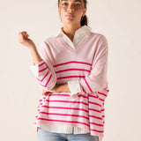 Woman wearing a pink and white striped sweater with a plain background