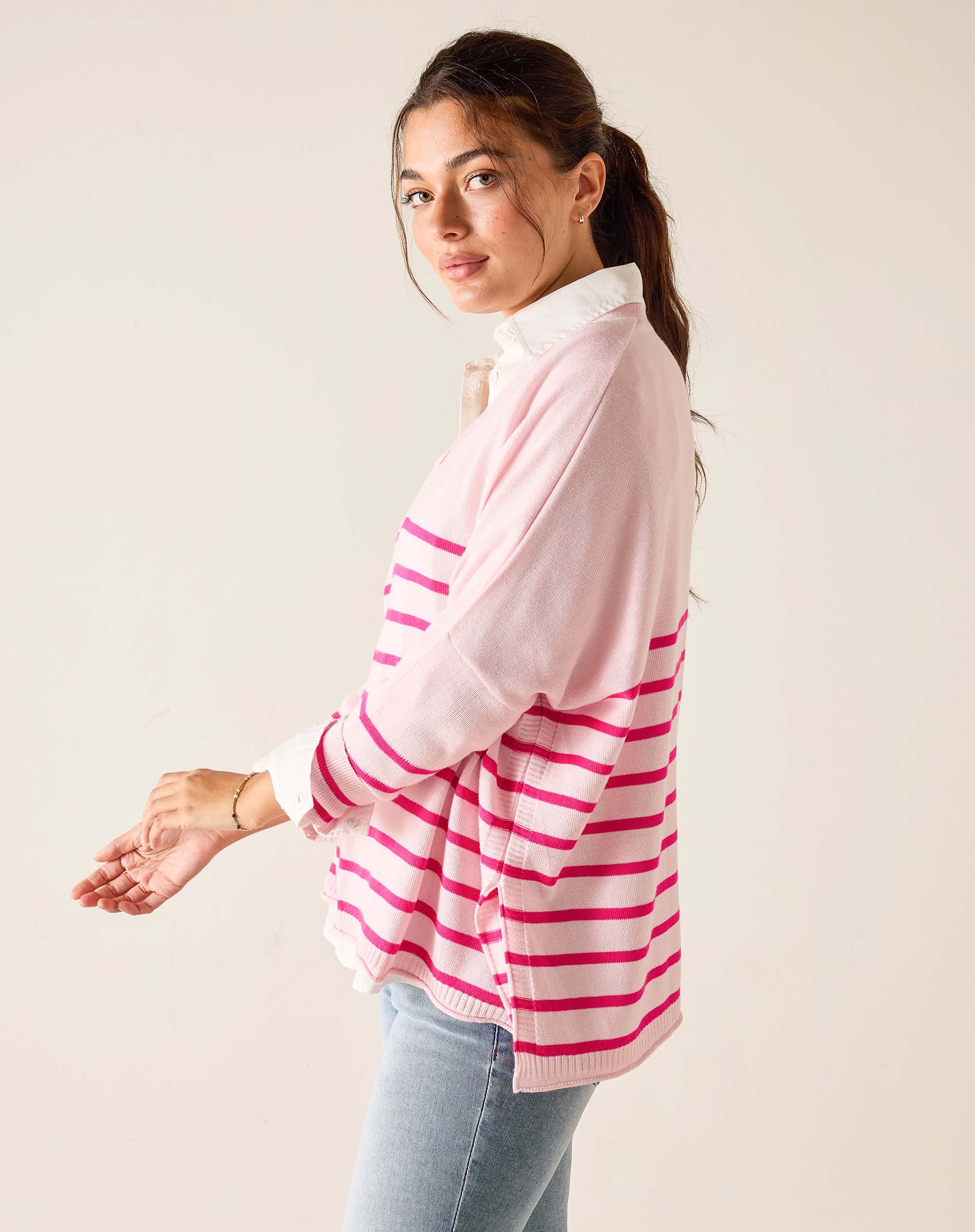 Woman wearing a pink and white striped shirt against a plain background