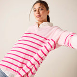 Woman wearing a pink and white striped sweater against a plain background