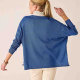 Woman wearing a blue sweater with a neutral background