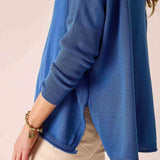 Blue sweater worn by a person on a beige background