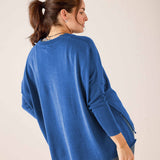 Side view of the ocean blue oversized knit V-neck sweater with ribbed hem and cuff details.