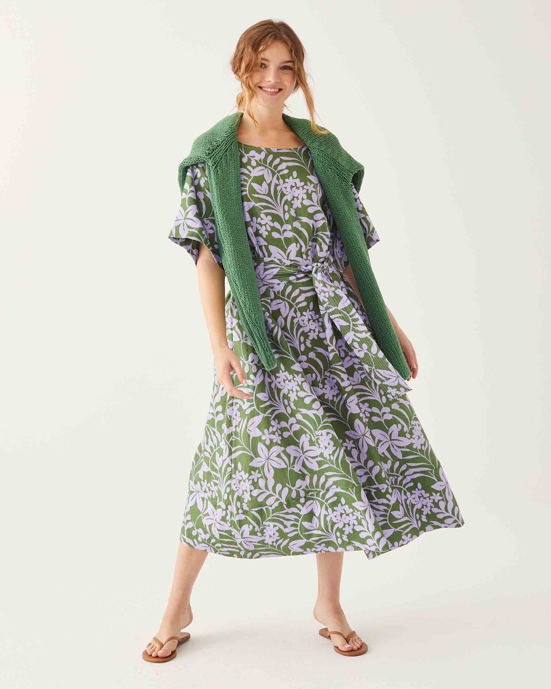 female wearing green linen midi dress with lavender floral print on a white background