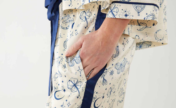 Women putting hands in silk pajama pant pocket with celestial print 