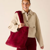 Garnet faux fur tote bag with plush texture and wide strap.