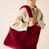 Garnet faux fur tote bag featuring a large oversized silhouette and plush material.