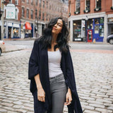 Woman standing on a cobblestone street in an urban setting