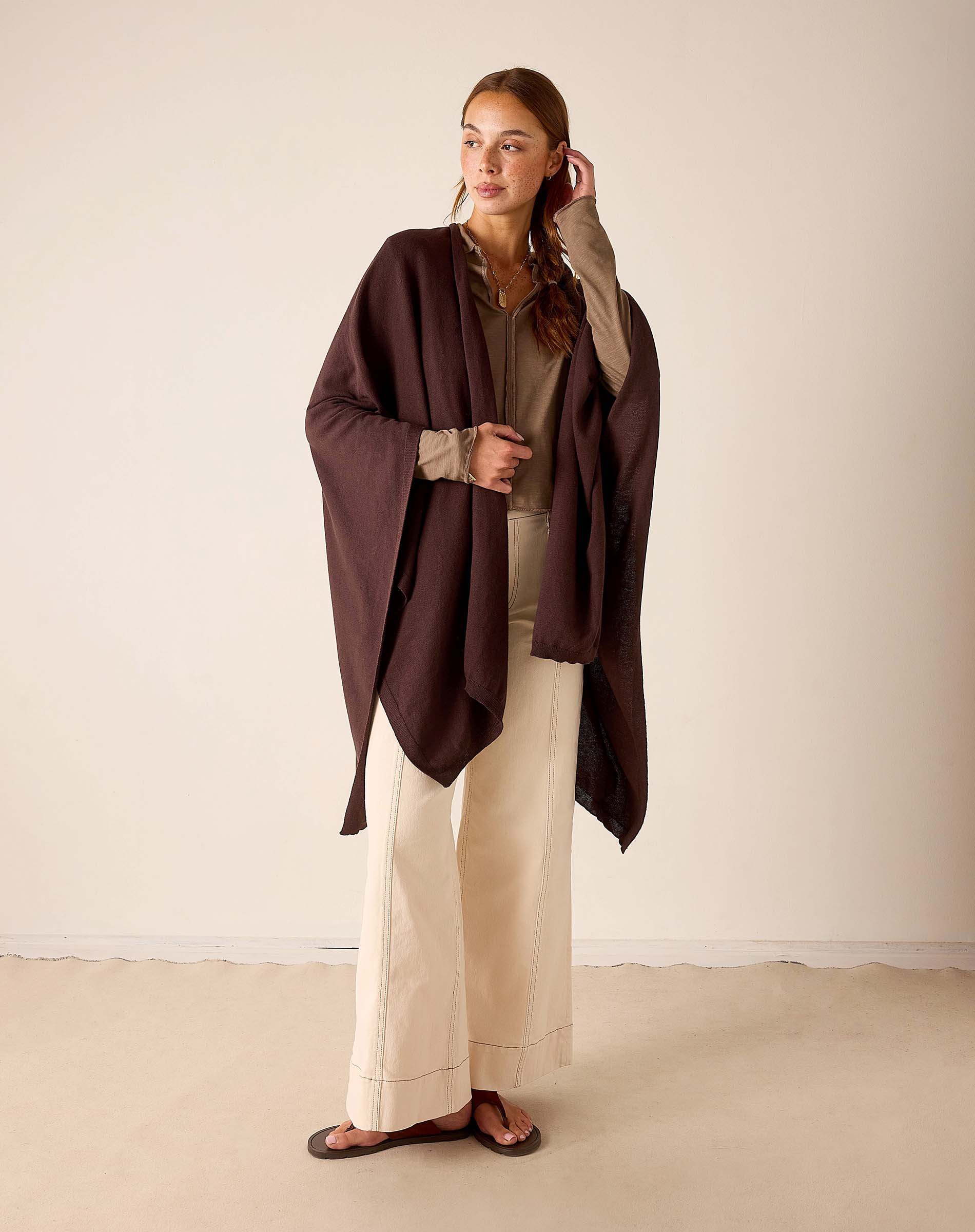 Chocolate brown wrap with a draped silhouette and long sleeves.