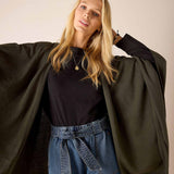 Olive green oversized knit wrap with a loose fit and draped sleeves.