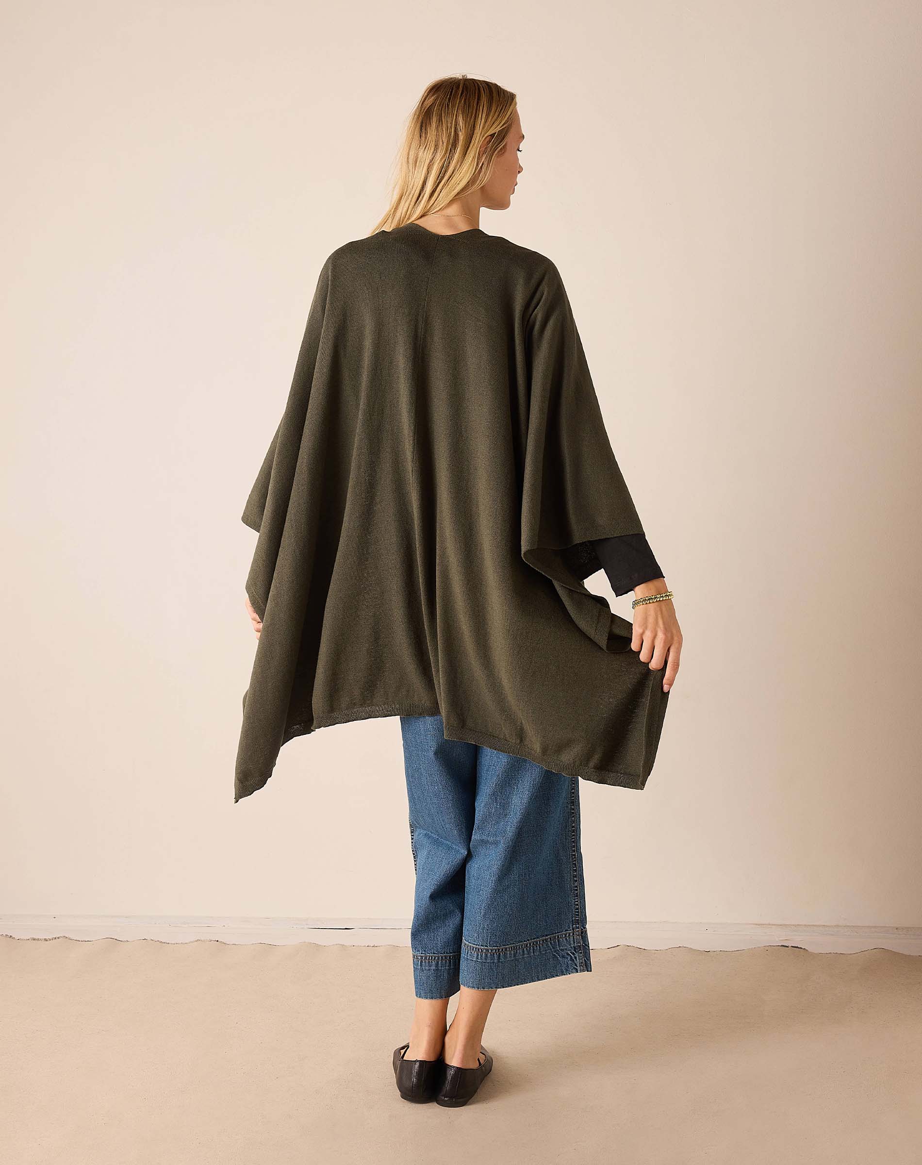 Back view of the olive wrap with a loose, draped silhouette and wide hem.