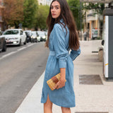 Woman in a blue dress standing on a city street