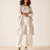 Woman wearing a beige outfit with a white background