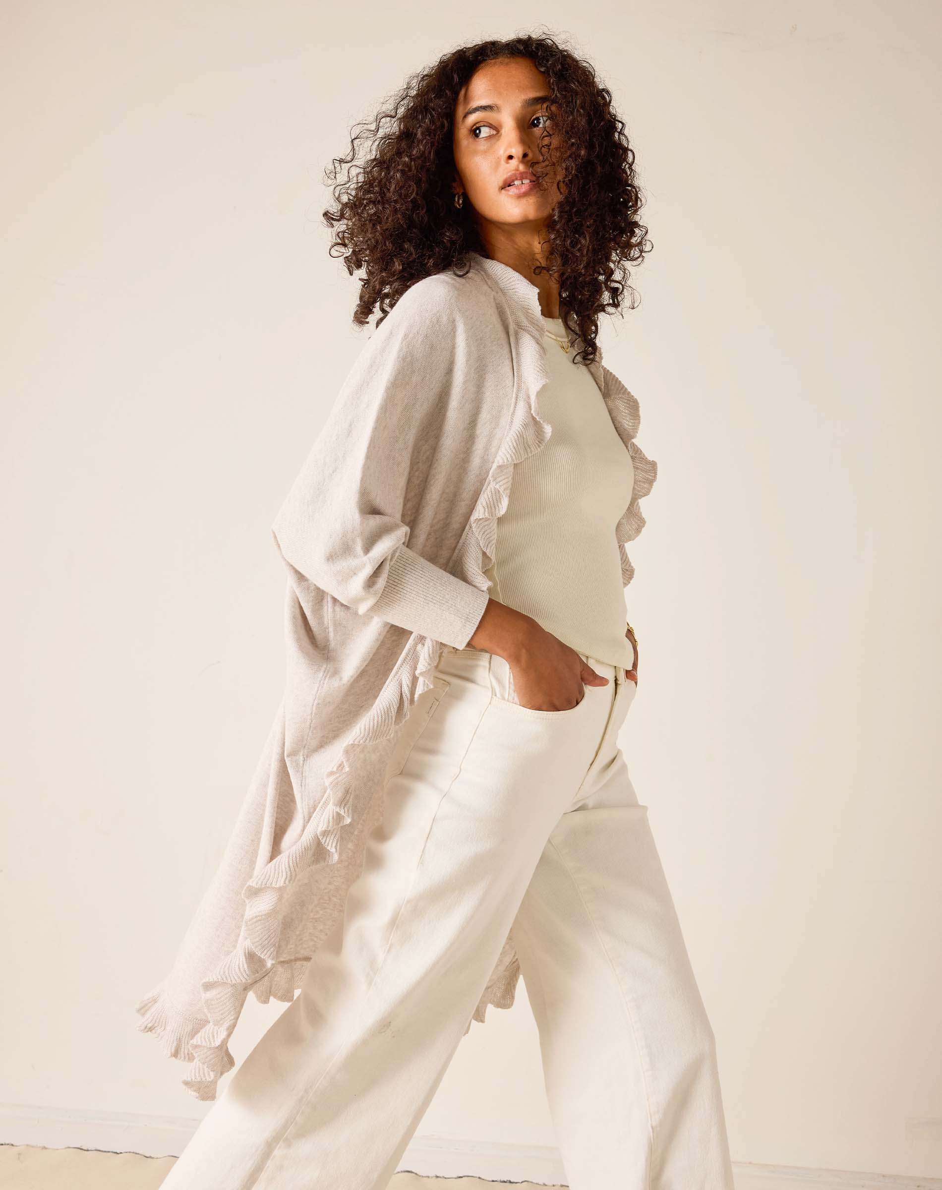 Woman wearing a light-colored outfit with a neutral background