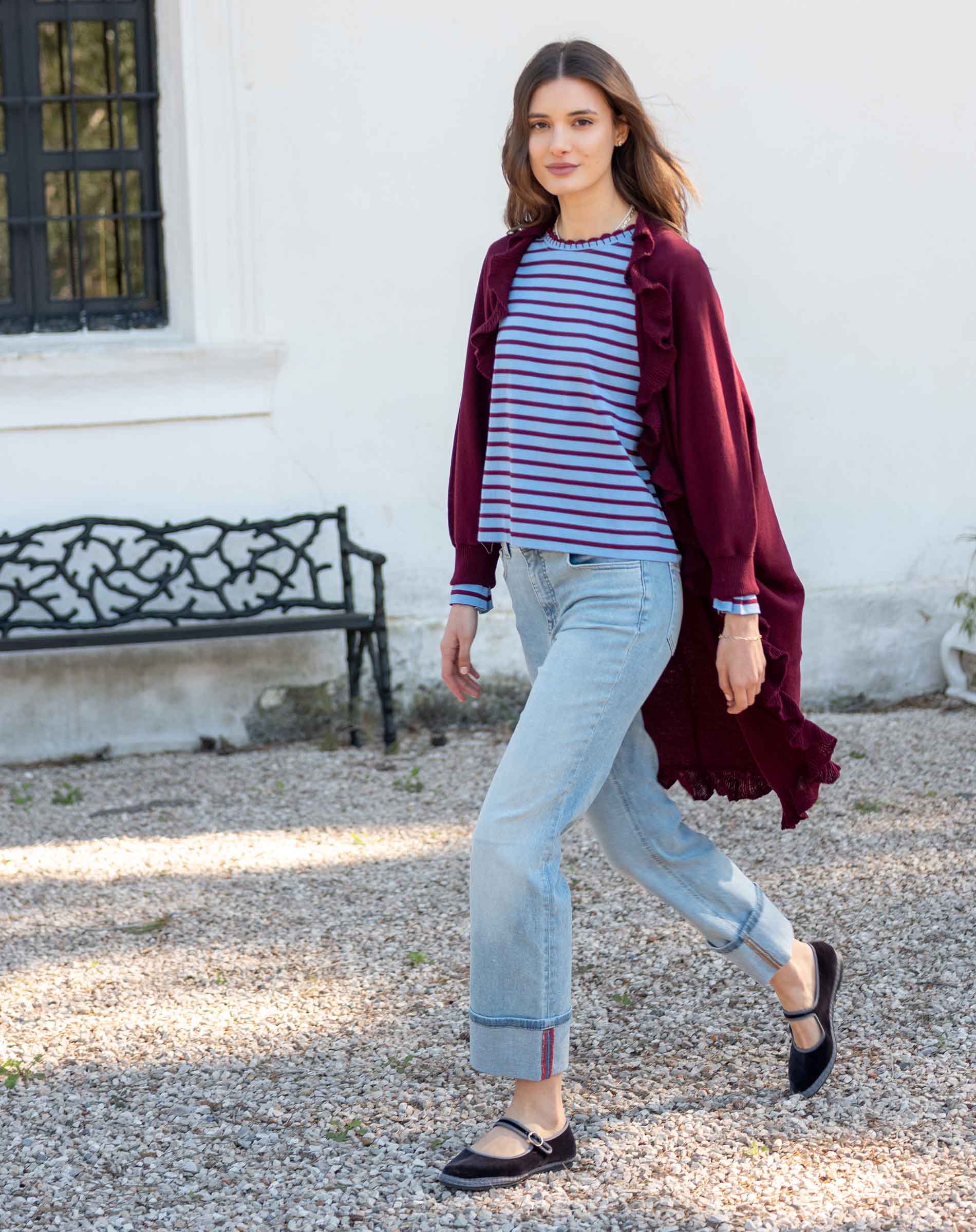 MERSEA ladies' travel-ready women's travel-friendly wine-colored ruffled kimono wrap worn over a striped knit top and light denim jeans.