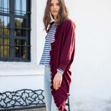 Model wearing a wine-colored ruffled kimono wrap over a striped tee and light-wash denim jeans.
