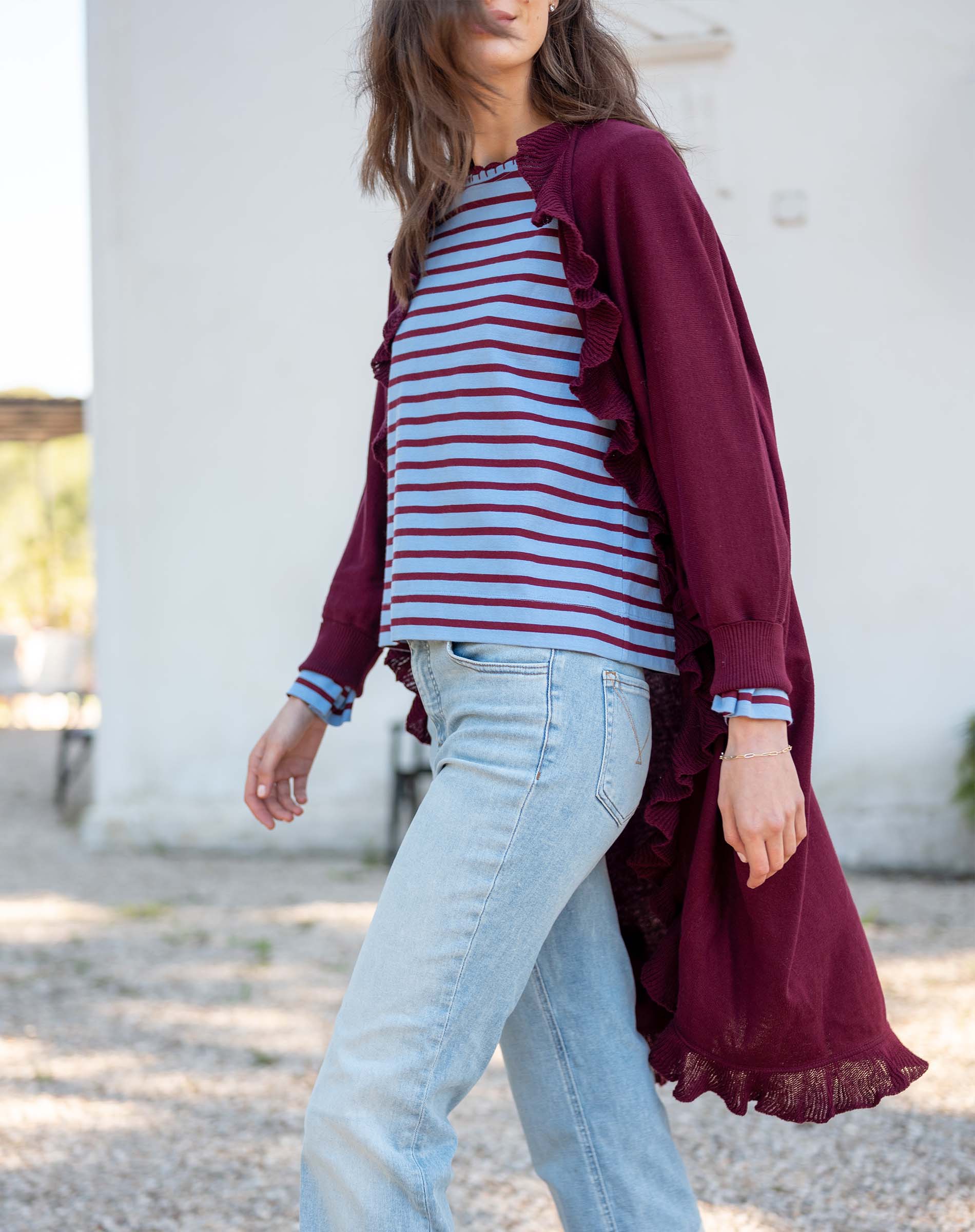 Wine-colored ruffle kimono wrap over a striped knit top and light-wash jeans.