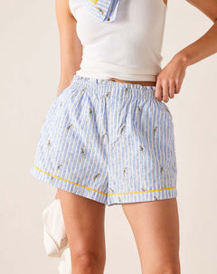 Person wearing light blue striped shorts with small patterns on a plain background