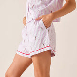 Pink and white striped pajama set with small patterns on a beige background