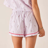 Person wearing a pink and white striped pajama set with small patterns on a beige background