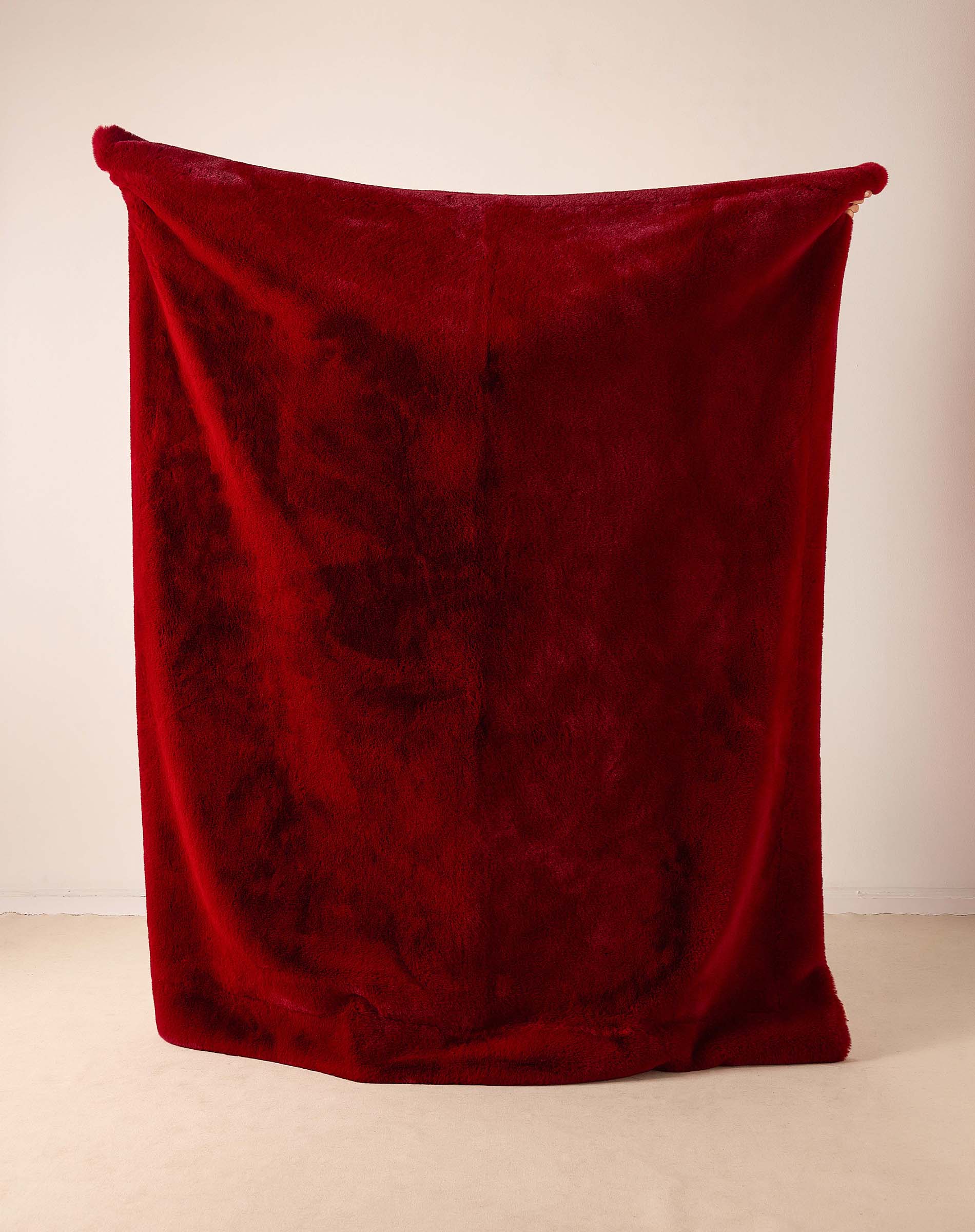 Garnet faux fur throw with a plush, voluminous pile.