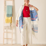 Woman wearing a colorful scarf with a ladder and towels in the background