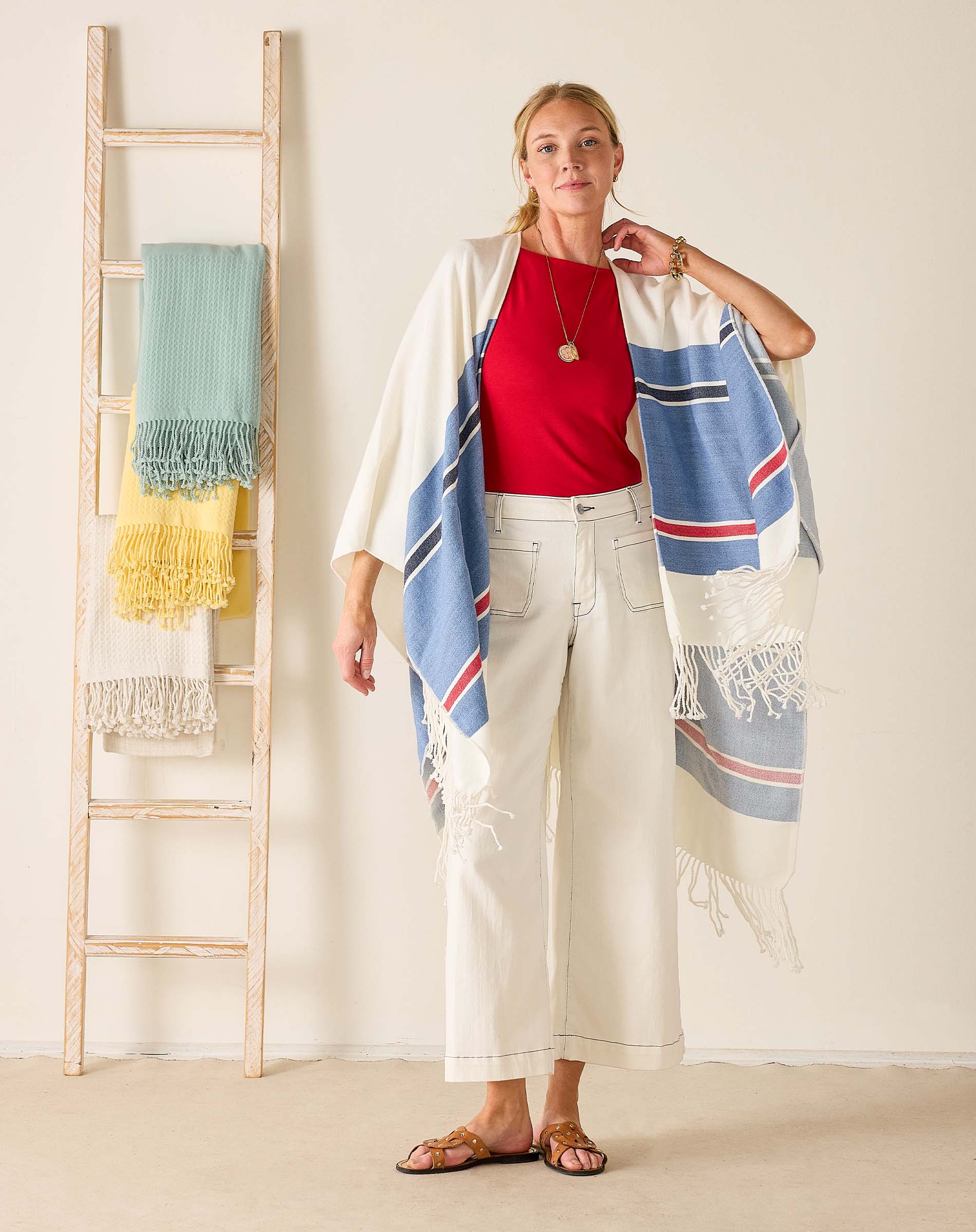 Woman wearing a colorful scarf with a ladder and towels in the background