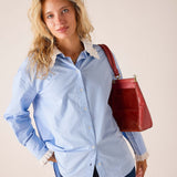 Women's travel-friendly bleu button-down shirt with a detachable lace-trimmed collar and ruffled cuffs.
