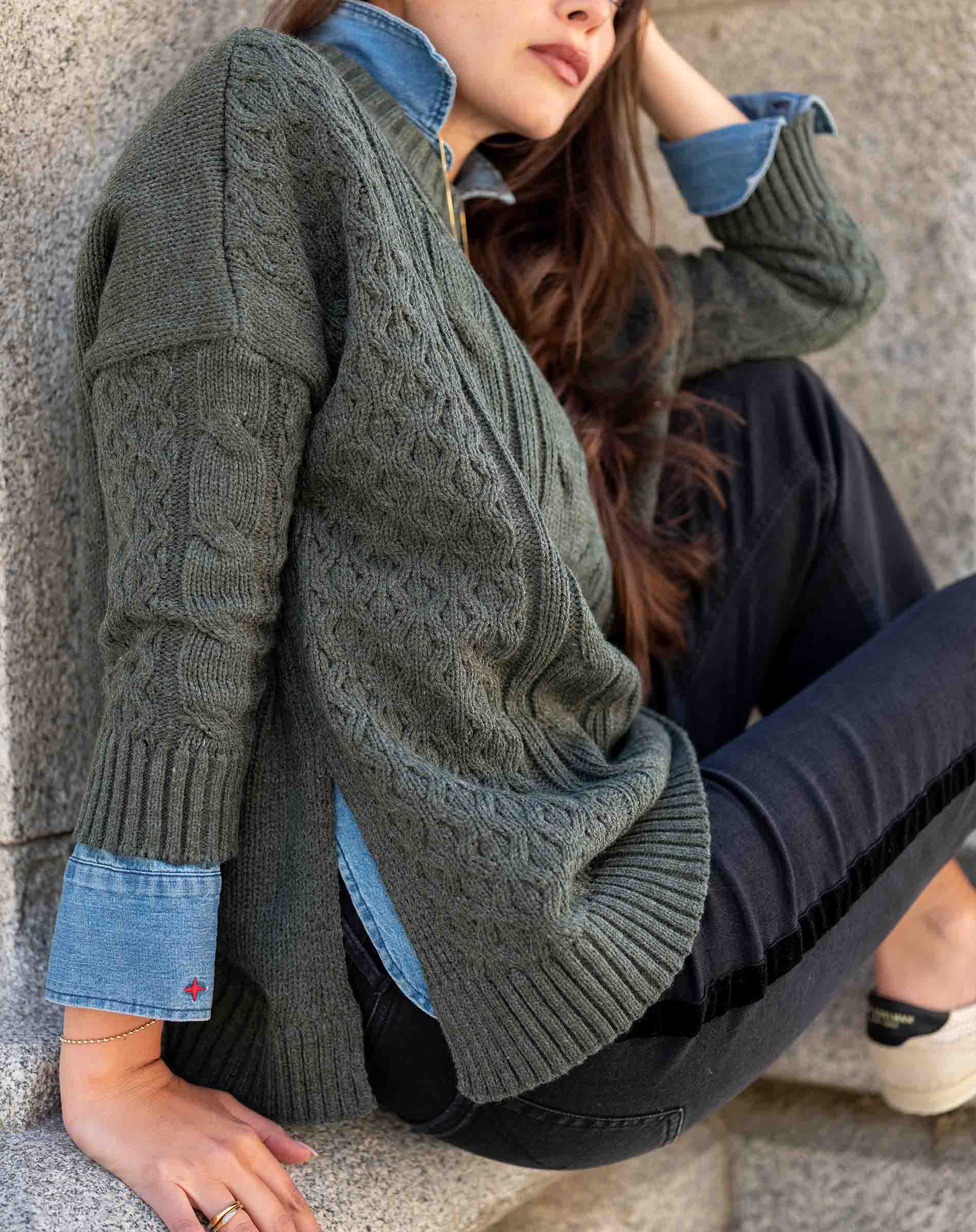 Army green chunky cable knit sweater featuring a relaxed fit and oversized cuffs.