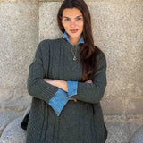 Army green cable-knit oversized sweater with a buttoned collar and denim lining.