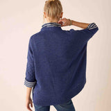Back view of the dusk blue cable knit sweater with striped ribbed cuffs and hem.