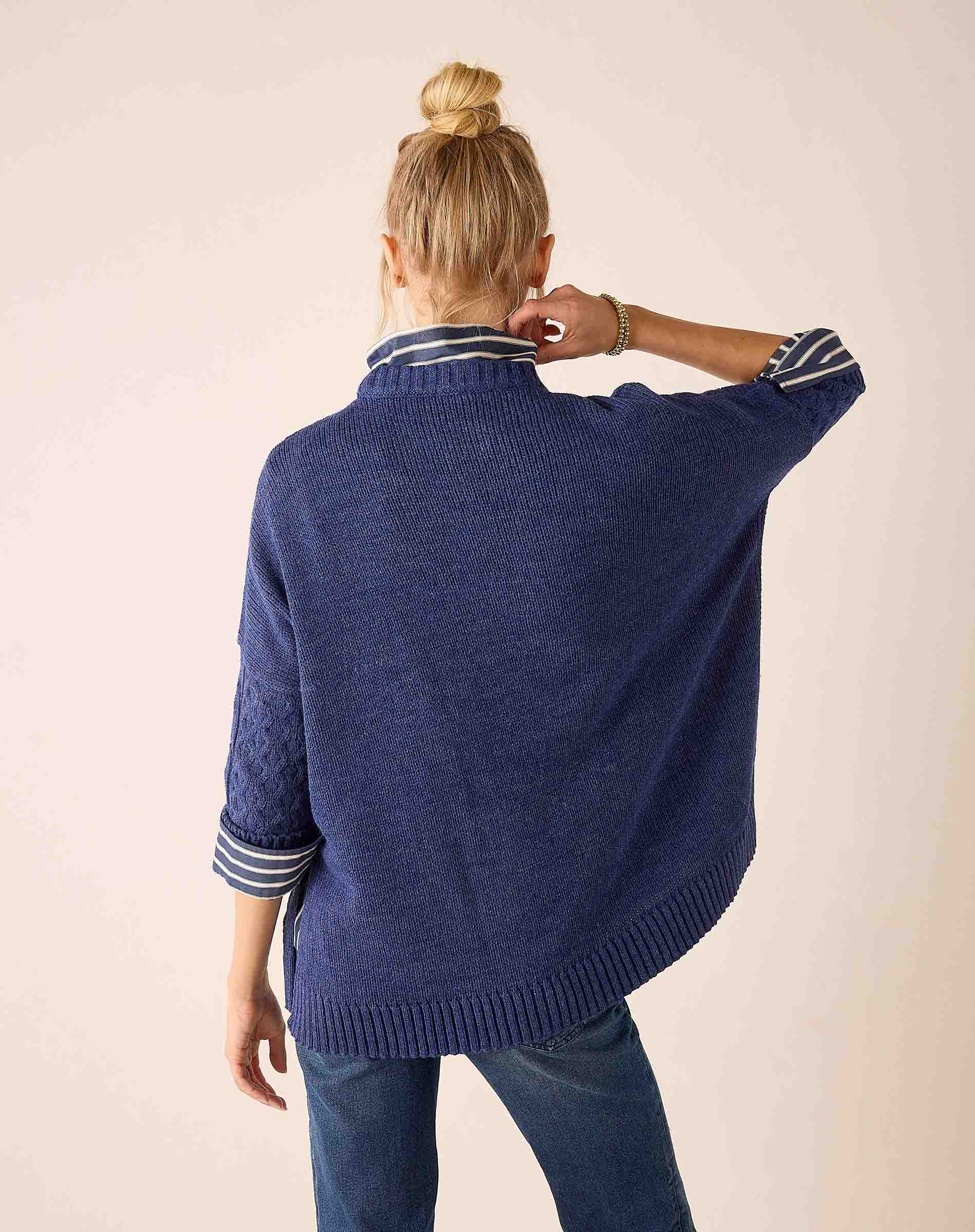 Back view of the dusk blue cable knit sweater with striped ribbed cuffs and hem.
