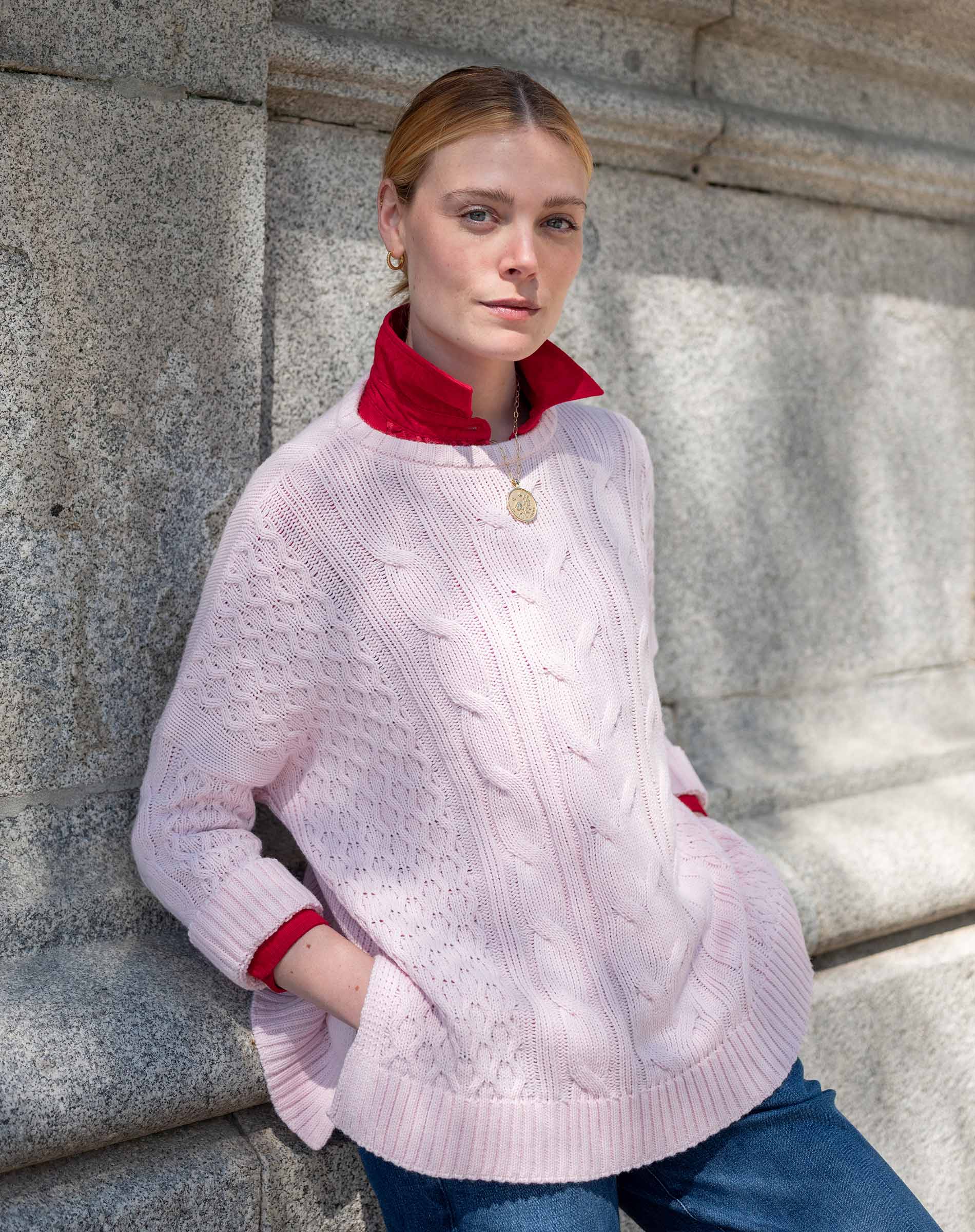 Women's travel-friendly petal pink cable knit sweater with a textured weave and full-length sleeves.