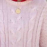 Petal pink cable knit sweater with a cozy, chunky knit and rounded neckline.