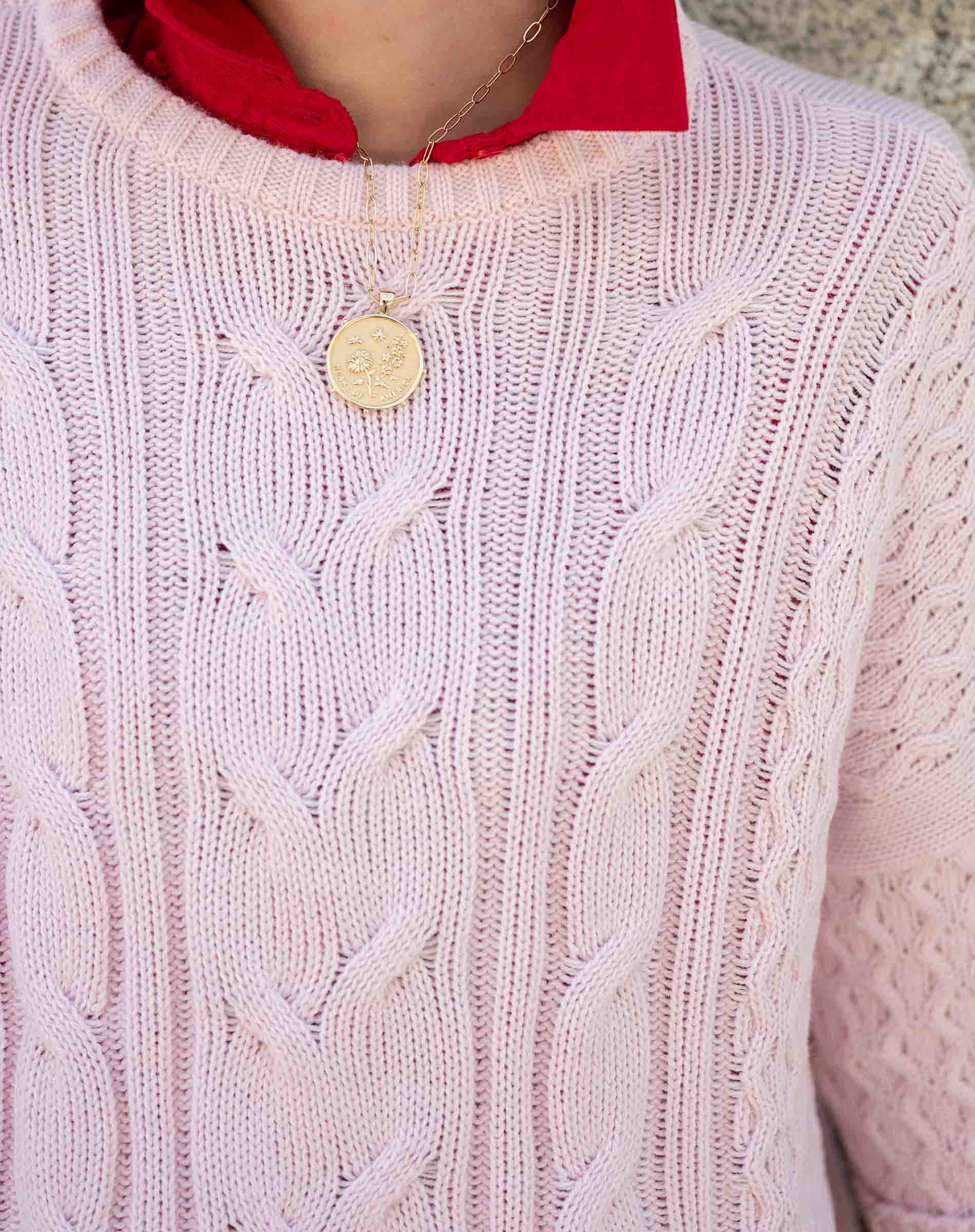 Petal pink cable knit sweater with a cozy, chunky knit and rounded neckline.
