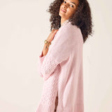 Light pink oversized knit sweater with a cable-knit pattern.