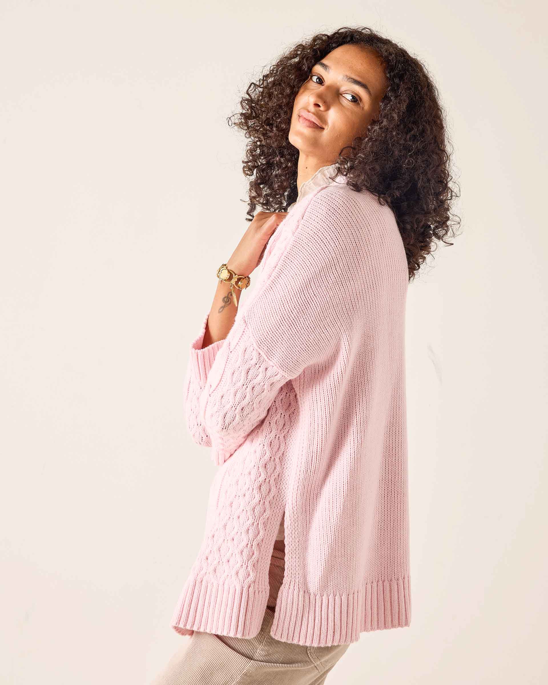 Light pink oversized knit sweater with a cable-knit pattern.