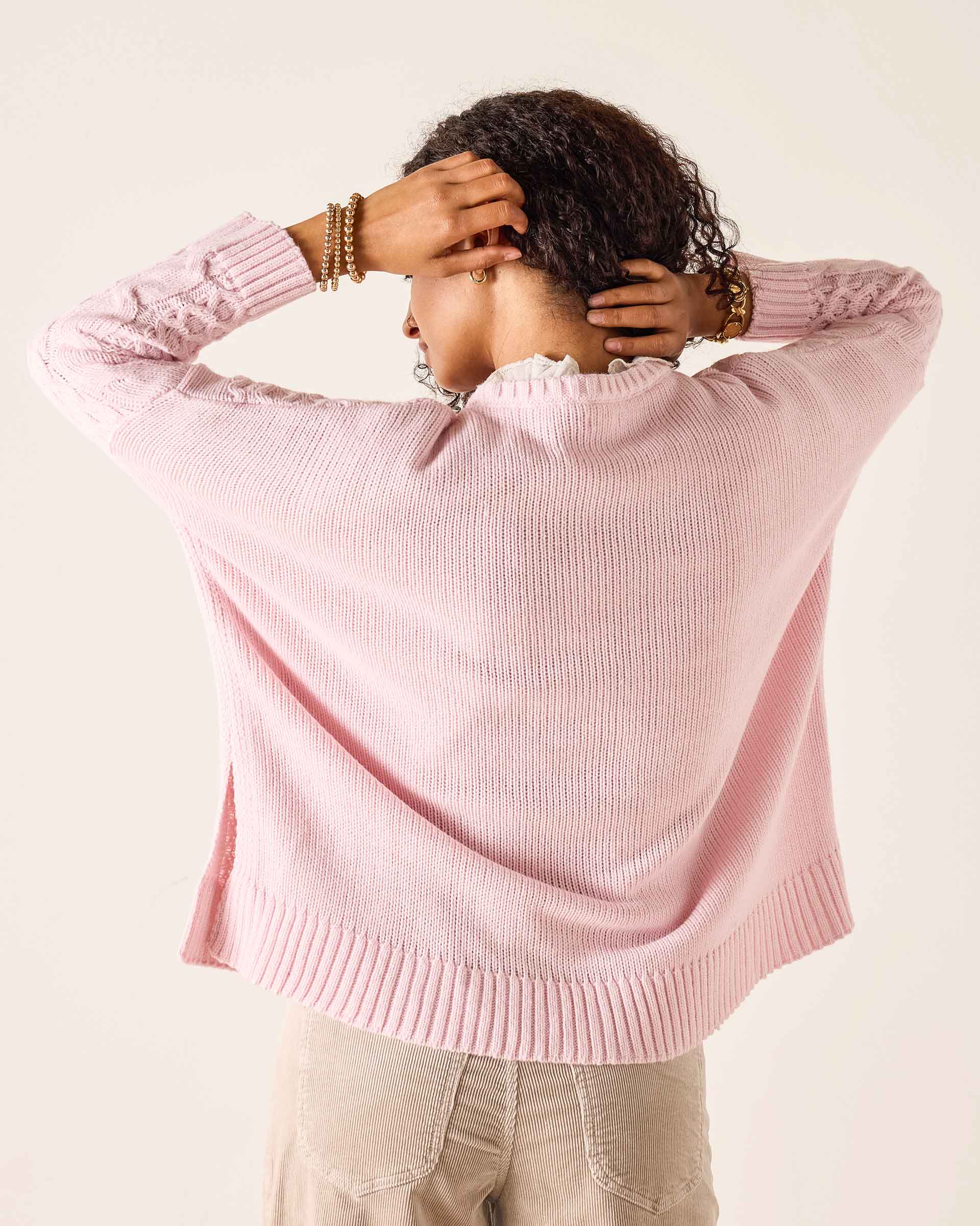 Light pink ribbed knit sweater with dropped shoulders and a wide ribbed hem.