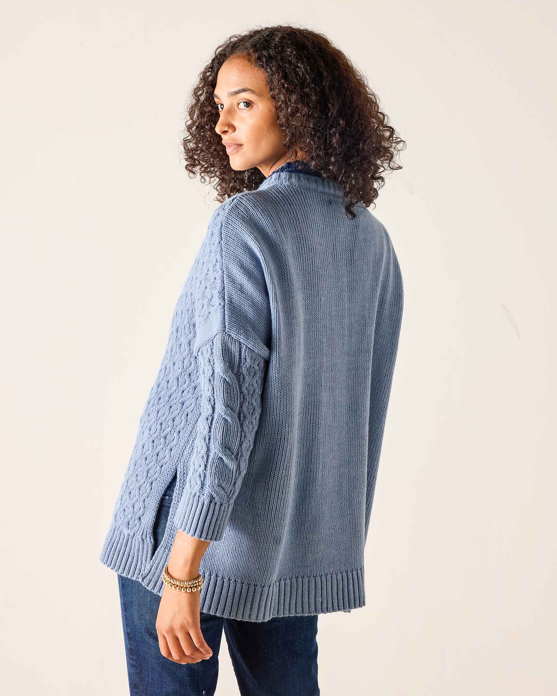 Misty blue cable knit sweater with a ribbed hem and textured details