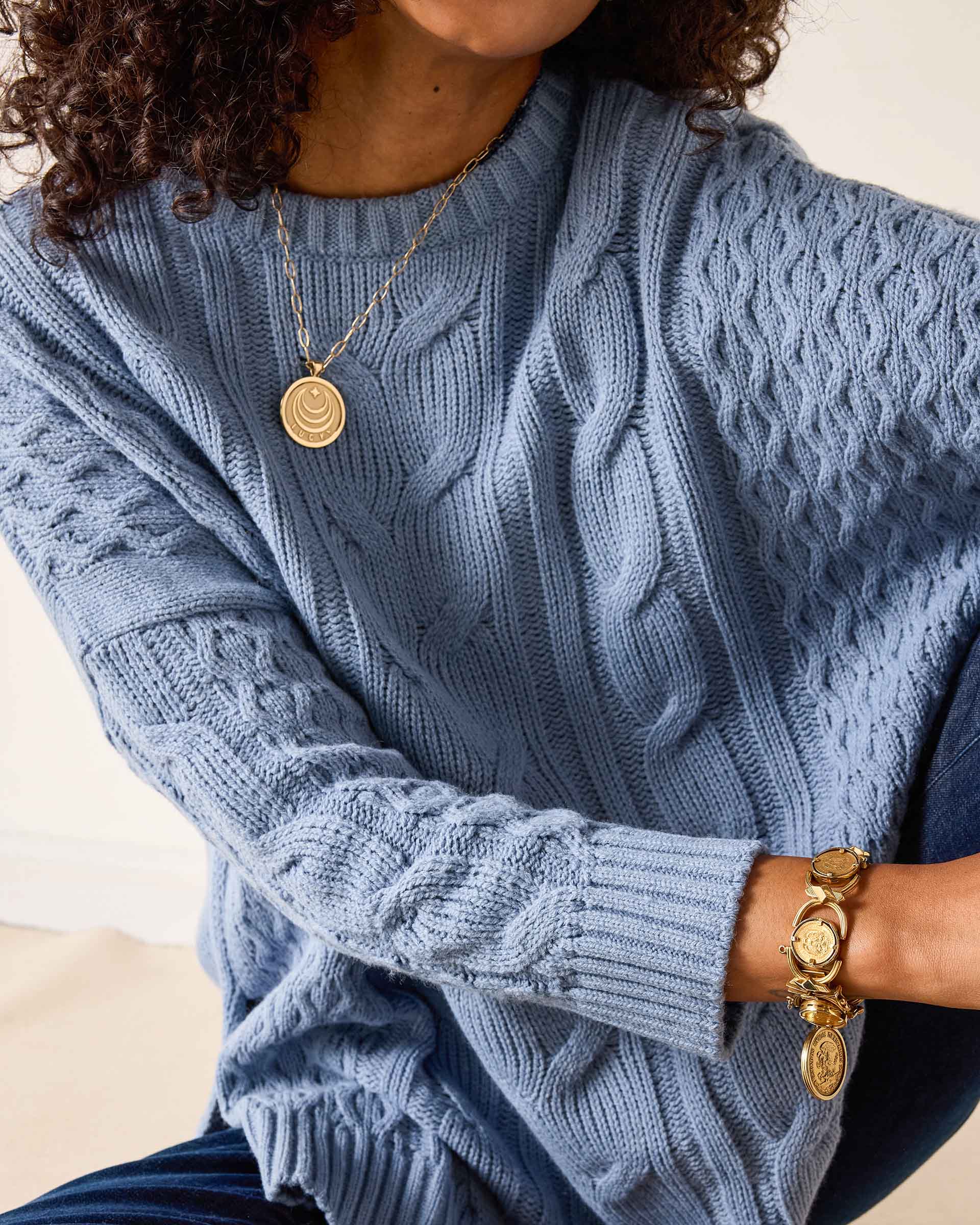 Misty blue cable knit sweater with a ribbed hem and cuffs.