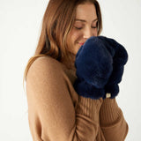 closeup of woman wearing mersea cozy cabin faux fur mittens in oxford blue