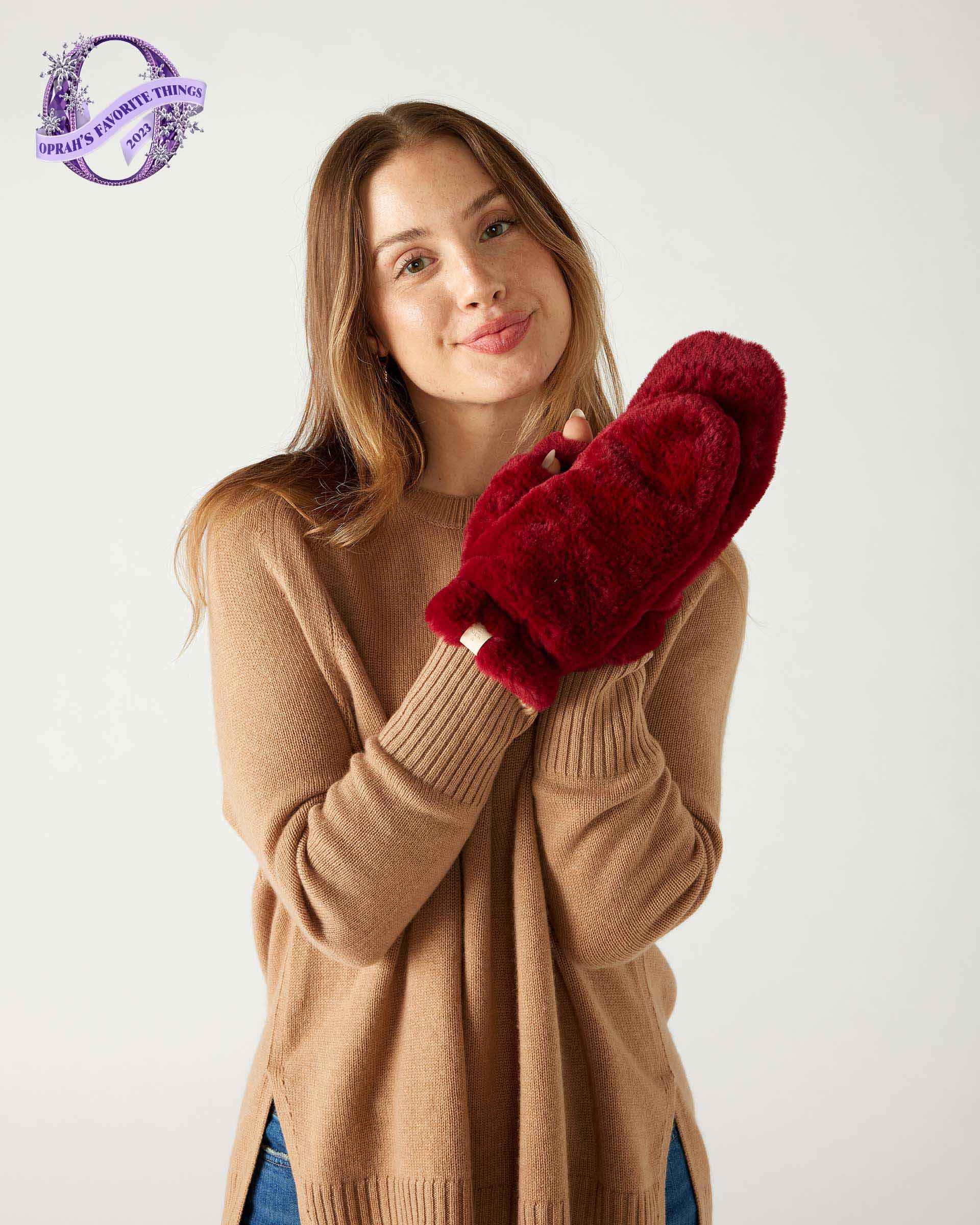 woman wearing mersea cozy cabin faux fur mittens in wine color