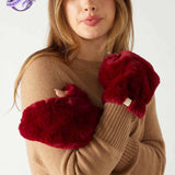 closeup of woman wearing mersea cozy cabin faux fur mittens in wine color