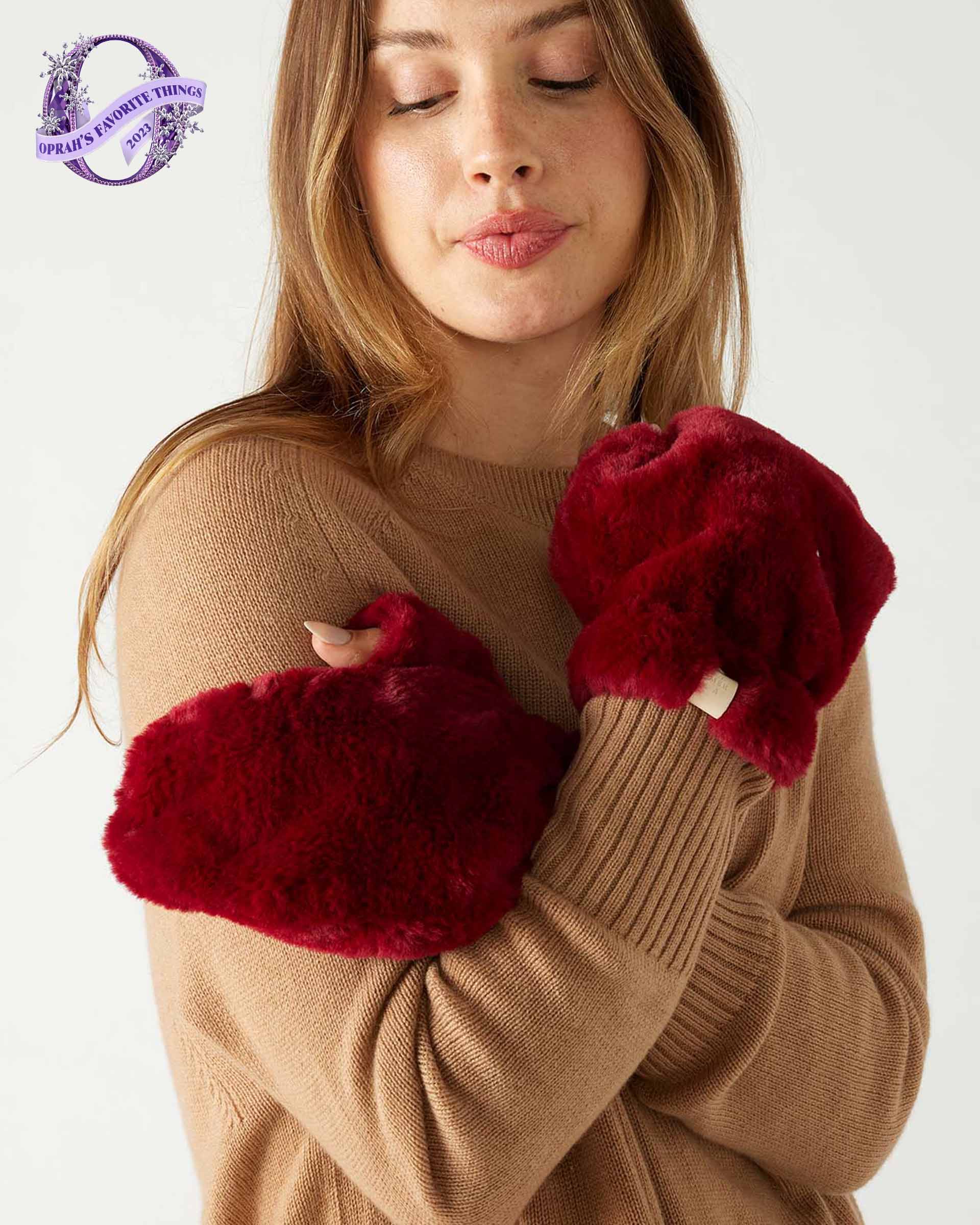 closeup of woman wearing mersea cozy cabin faux fur mittens in wine color